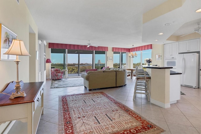 living room featuring light tile patterned flooring and ceiling fan with notable chandelier