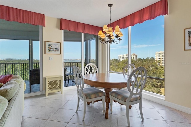 dining area with a healthy amount of sunlight, light tile patterned floors, and an inviting chandelier