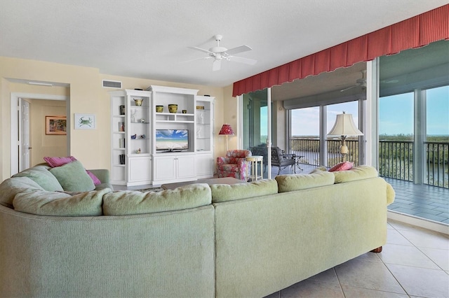 living room featuring ceiling fan, tile patterned floors, and a textured ceiling