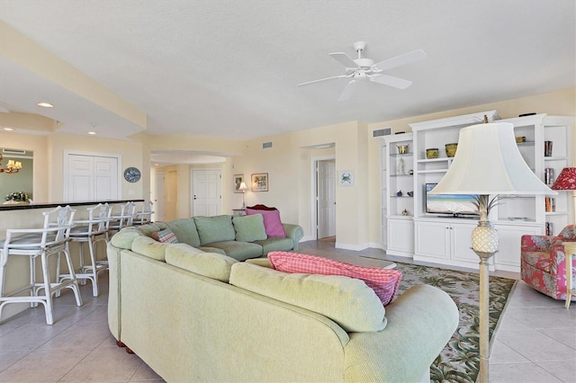 tiled living room with a textured ceiling and ceiling fan