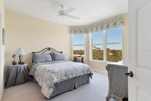 carpeted bedroom featuring a water view and ceiling fan