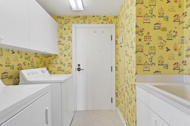 clothes washing area featuring cabinets, washing machine and clothes dryer, and light tile patterned flooring