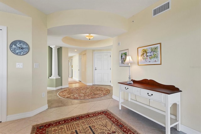 hallway featuring tile patterned flooring and decorative columns