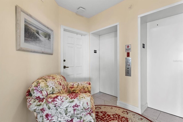 living area featuring elevator and light tile patterned floors