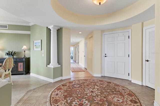 entryway featuring tile patterned floors and ornate columns