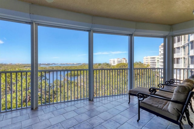 sunroom featuring a water view