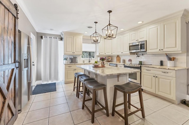 kitchen featuring a breakfast bar area, light stone counters, a center island, appliances with stainless steel finishes, and pendant lighting