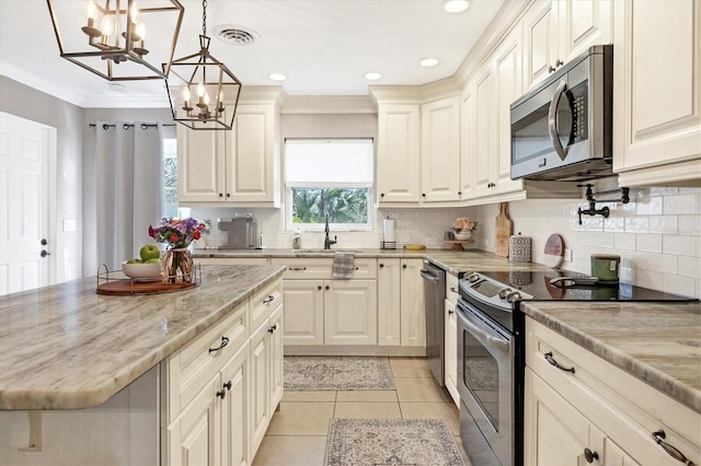 kitchen featuring sink, light tile patterned floors, stainless steel appliances, light stone counters, and decorative light fixtures