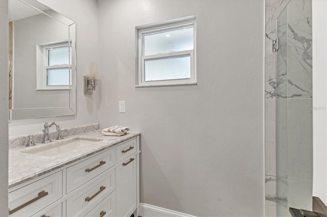 bathroom featuring vanity, a wealth of natural light, and walk in shower