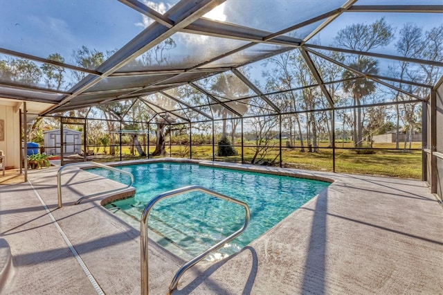 view of pool with a yard, a patio area, glass enclosure, and a shed