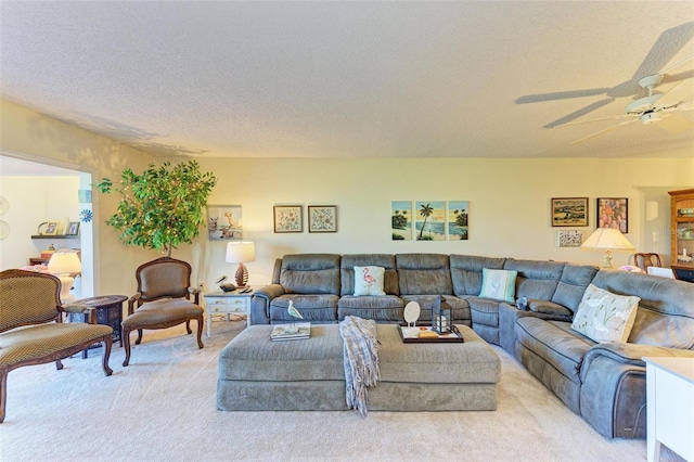 carpeted living room featuring ceiling fan and a textured ceiling