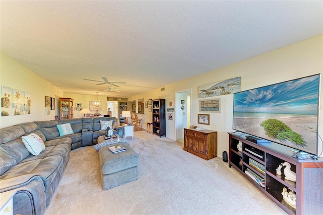 carpeted living room featuring ceiling fan and a textured ceiling