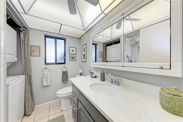 full bathroom featuring ceiling fan, toilet, stacked washer and clothes dryer, tile patterned floors, and vanity