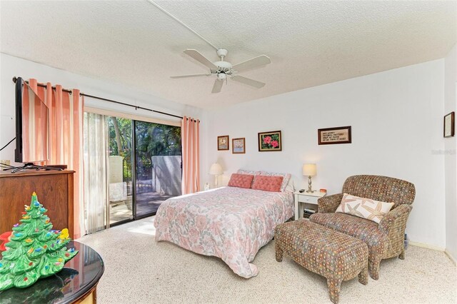 carpeted bedroom with ceiling fan, access to exterior, and a textured ceiling