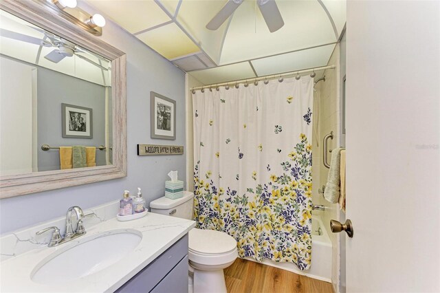 full bath featuring toilet, wood finished floors, vanity, a ceiling fan, and shower / bathtub combination with curtain