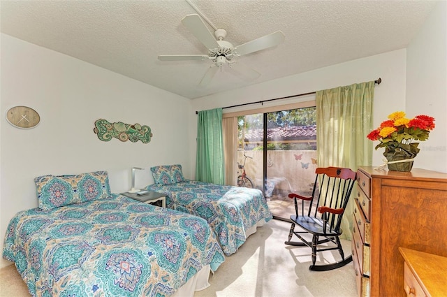 bedroom featuring access to exterior, a textured ceiling, light carpet, and a ceiling fan