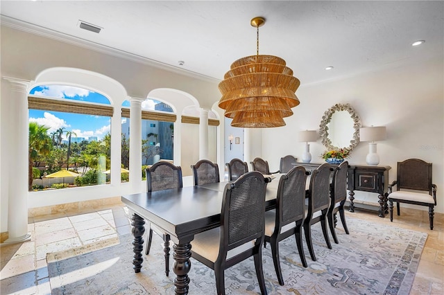 dining space featuring decorative columns and crown molding