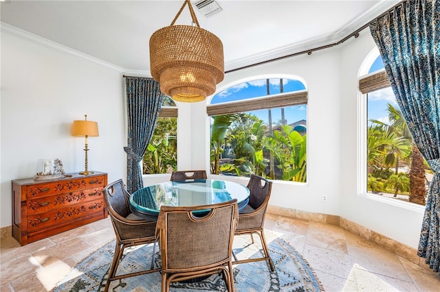 dining space with crown molding and a chandelier