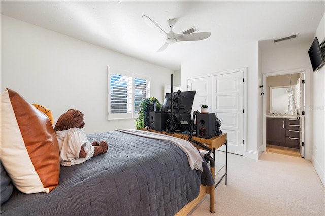 carpeted bedroom with ensuite bathroom, ceiling fan, and a closet