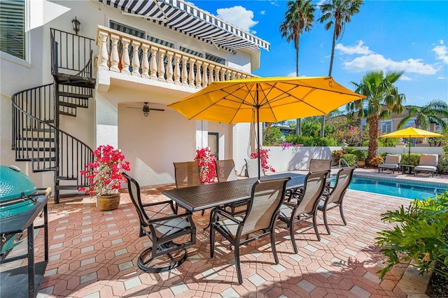 view of patio with a fenced in pool, a balcony, and grilling area