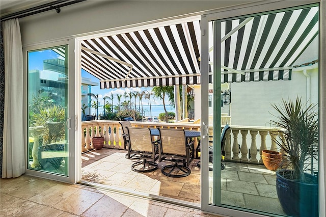 doorway to outside featuring lofted ceiling and stone tile floors