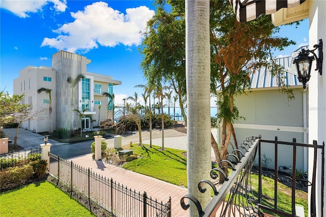 view of property's community with a fenced front yard and a lawn