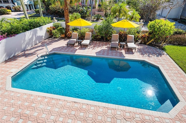 view of swimming pool featuring a patio area, fence, and a fenced in pool