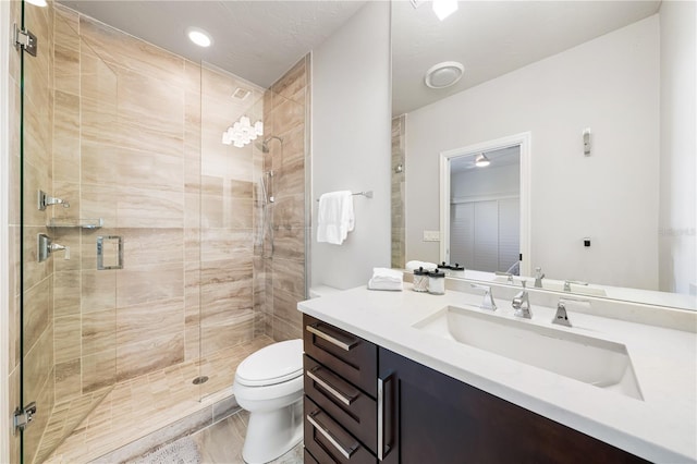 bathroom featuring a stall shower, vanity, and toilet