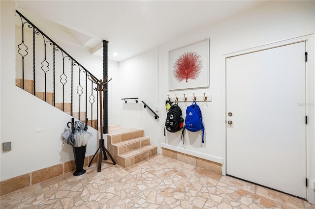 entrance foyer with stairs and stone tile flooring