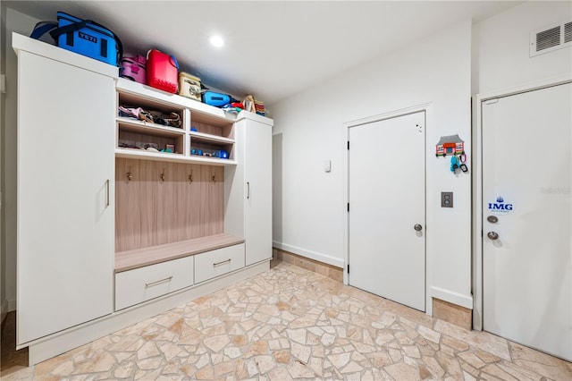 mudroom with stone finish floor and visible vents