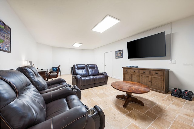 living room featuring baseboards and stone tile flooring