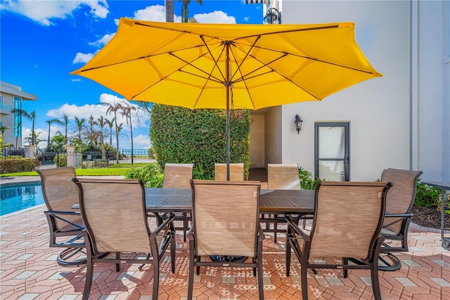 view of patio with fence, a fenced in pool, and outdoor dining space