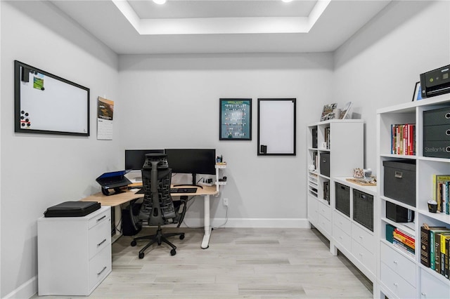 office with a raised ceiling and light hardwood / wood-style floors