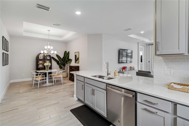 kitchen featuring gray cabinetry, sink, a raised ceiling, and dishwasher