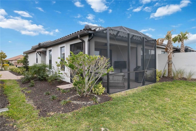 rear view of house featuring a yard, a lanai, and a patio area