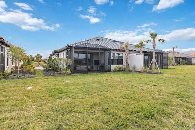 back of house featuring glass enclosure and a lawn