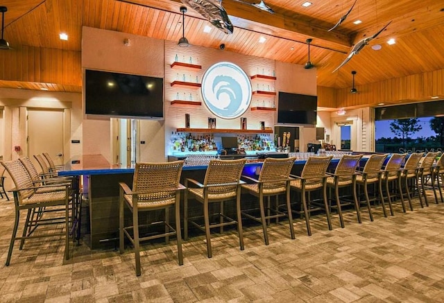 bar with beam ceiling, a high ceiling, wood ceiling, and decorative light fixtures