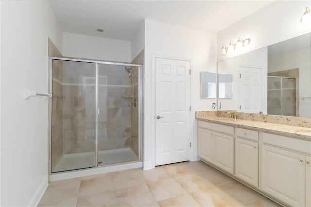 bathroom featuring tile patterned floors, vanity, and a shower with door