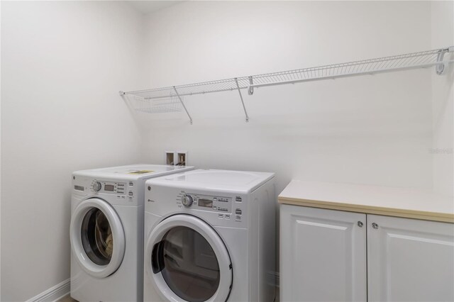 clothes washing area featuring cabinets and independent washer and dryer