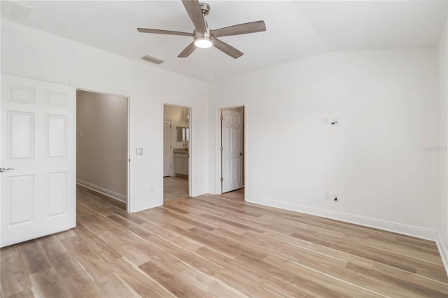 unfurnished bedroom featuring lofted ceiling, ensuite bath, ceiling fan, and light hardwood / wood-style floors