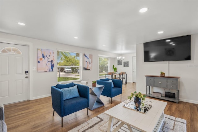 living room with an inviting chandelier and light wood-type flooring