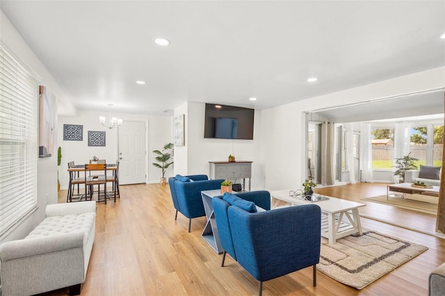 living room with an inviting chandelier and light wood-type flooring