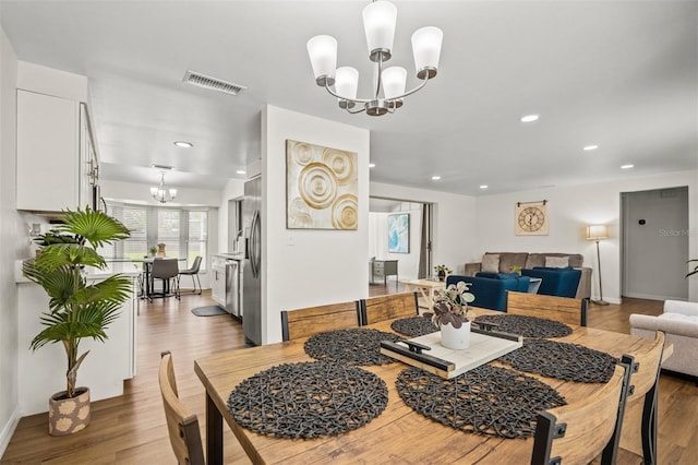 dining area featuring a chandelier and light hardwood / wood-style floors