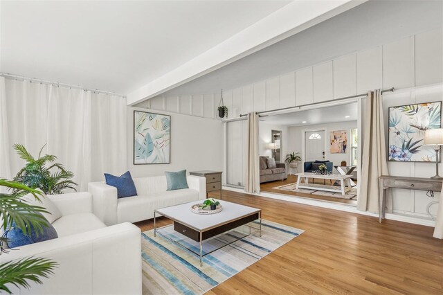 living room featuring wood-type flooring and beam ceiling