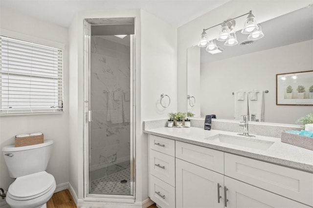 bathroom featuring vanity, toilet, and walk in shower