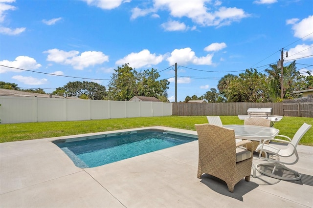 view of swimming pool featuring a patio, a grill, and a yard