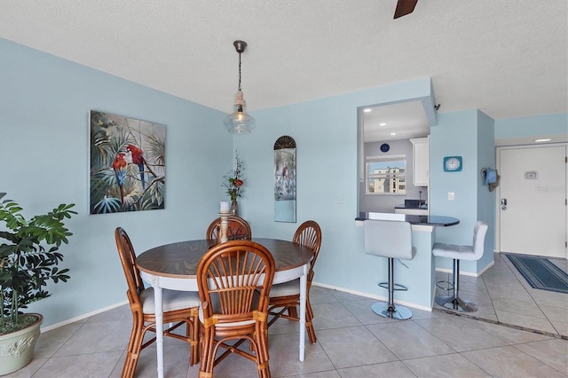 dining space featuring light tile patterned floors and a textured ceiling