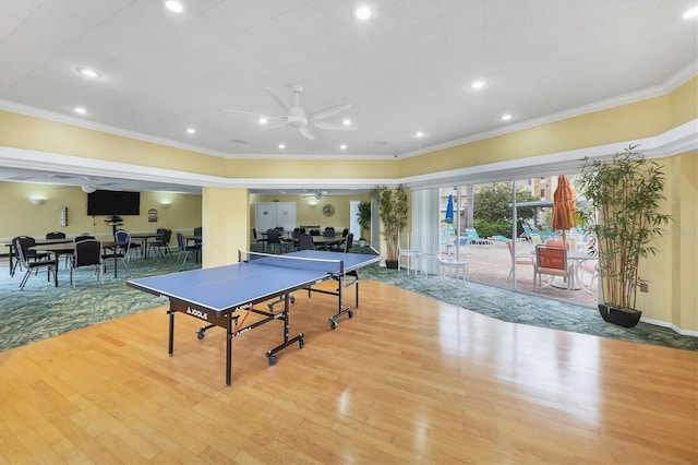 recreation room featuring crown molding, light hardwood / wood-style floors, and ceiling fan