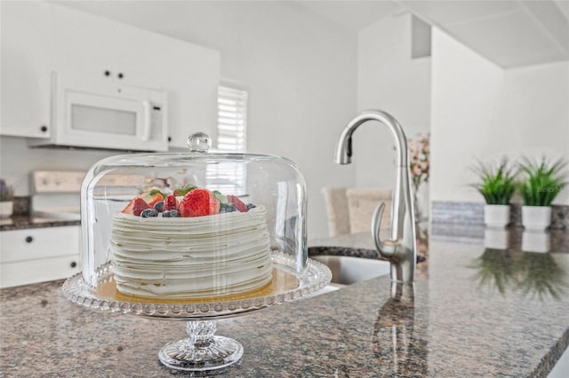 room details featuring sink and dark stone counters