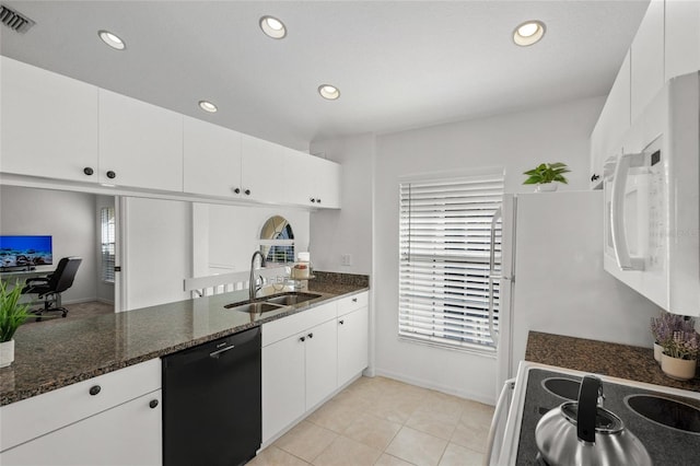 kitchen with a wealth of natural light, sink, dark stone countertops, white cabinets, and white appliances